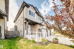 Two-story residence featuring light-colored siding and dark trim - 