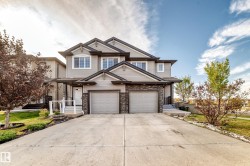 Two-story home with a light gray siding exterior and dark gray stone accents - 