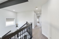 Open staircase with dark wood-finish handrail and wrought iron spindles - 