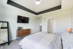 Tray ceiling with accent paint, wall-mounted television, and carpet flooring - 