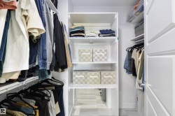 Custom closet system featuring multiple hanging rods, adjustable shelving, and a bright white finish - 