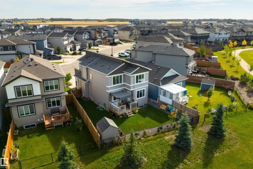 Contemporary two-story residence with a multi-level deck, fenced yard, and adjacent green space - 1032 Berg Place, Leduc, AB 
