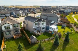Contemporary two-story residence with a multi-level deck, fenced yard, and adjacent green space - 