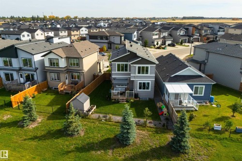 Modern residential exterior featuring a multi-level deck, fenced yard, and storage shed - 1032 Berg Place, Leduc, AB 