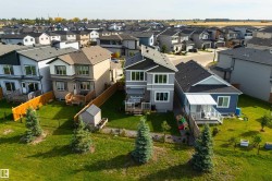 Modern residential exterior featuring a multi-level deck, fenced yard, and storage shed - 