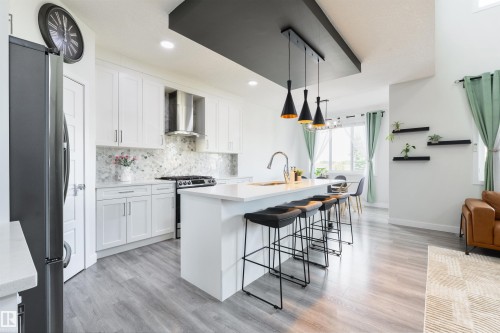 White shaker cabinetry with a marble-look backsplash and stainless steel appliances - 1032 Berg Place, Leduc, AB 