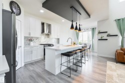 White shaker cabinetry with a marble-look backsplash and stainless steel appliances - 