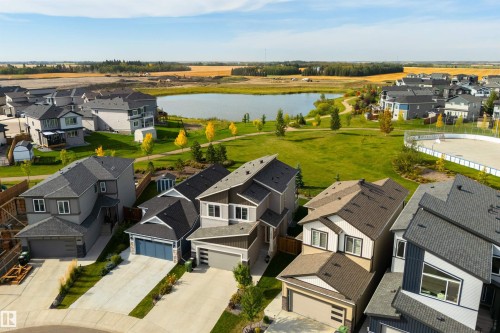New construction homes with attached garages, multi-pane windows, and a paved driveway - 1032 Berg Place, Leduc, AB 