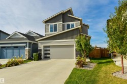 Contemporary exterior with varied siding textures, a multi-pane garage door, and a concrete driveway - 
