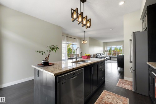 Kitchen island with integrated stainless steel dishwasher, undermount sink, and granite countertop - #1 1636 Kerr Rd Nw, Edmonton, AB 