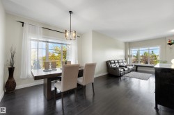 Open-concept living space with dark wood-finish flooring, recessed lighting, and large windows - 
