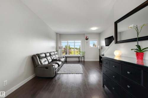 Dark wood-finish flooring with light wall tones and large windows - #1 1636 Kerr Rd Nw, Edmonton, AB 