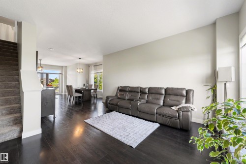 Dark wood-finish flooring throughout, light-toned walls, recessed lighting, and a carpeted staircase - #1 1636 Kerr Rd Nw, Edmonton, AB 