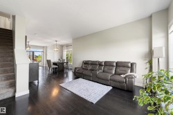 Dark wood-finish flooring throughout, light-toned walls, recessed lighting, and a carpeted staircase - 