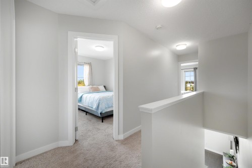 Neutral color palette with flush-mount ceiling lighting and soft carpeted flooring throughout the upper level - #1 1636 Kerr Rd Nw, Edmonton, AB 