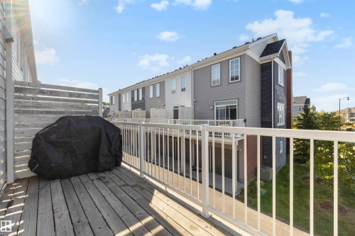 Exterior deck featuring wood-finish flooring and a white railing - #1 1636 Kerr Rd Nw, Edmonton, AB 