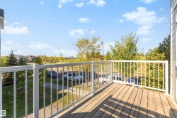 Balcony with wood-finish decking and white railing - 