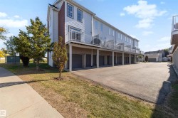 Multi-story building featuring individual balconies, ground-level garages, and light-colored siding - 