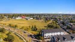 Residential neighborhood featuring a multi-story townhome complex with private balconies and a paved parking area - 