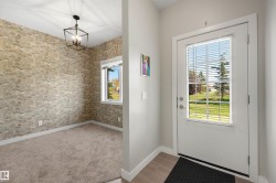 Recessed ceiling light fixture, accent wall with textured wallpaper, carpeted flooring, and a window with blinds - 
