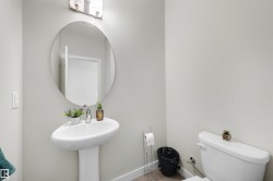 Pedestal sink with a polished chrome faucet and an oval wall mirror - 