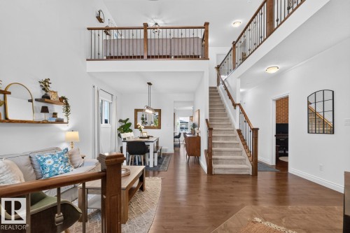 Hardwood flooring, high ceilings, open-concept design, staircase with wood handrails and wrought iron spindles, and a second-story balcony - 21 Altadena Point(E), Sherwood Park, AB 