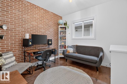 Exposed brick accent wall, wood-finish flooring, white trim window, built-in shelving, and recessed ceiling lighting - 21 Altadena Point(E), Sherwood Park, AB 