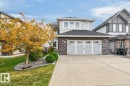 Two-story residence featuring light gray siding, stone facade accents, and a two-car garage with transom windows - 21 Altadena Point(E), Sherwood Park, AB 