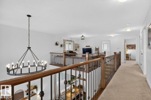 Loft area featuring wood and metal railings, carpeted hallway, chandelier lighting, and recessed ceiling lights - 21 Altadena Point(E), Sherwood Park, AB 
