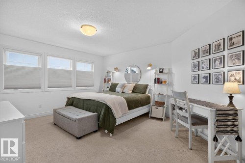 Bright room featuring three windows with horizontal blinds, neutral-toned carpet flooring, and white painted walls - 21 Altadena Point(E), Sherwood Park, AB 