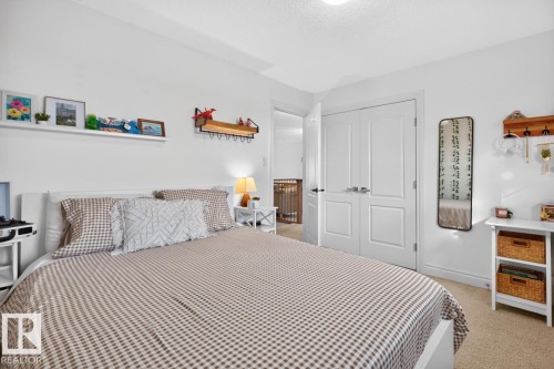 White painted walls with wall shelving, dual panel doors, and neutral carpeting - 21 Altadena Point(E), Sherwood Park, AB 