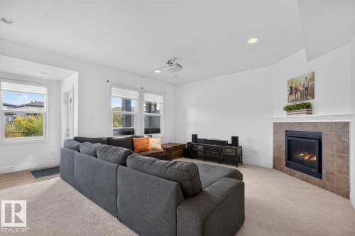 Recessed lighting, multiple windows, a corner fireplace with a tiled surround, and light-toned carpeting - 21 Altadena Point(E), Sherwood Park, AB 