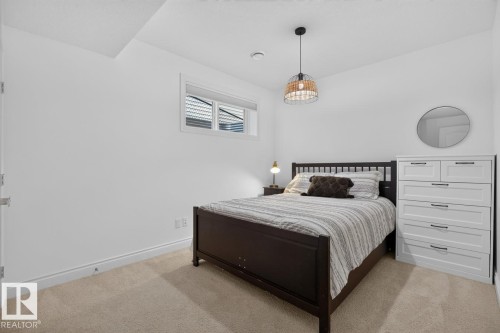 Recessed window with blinds, overhead pendant light fixture, and neutral carpet flooring - 21 Altadena Point(E), Sherwood Park, AB 