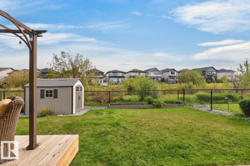 Expansive backyard featuring a manicured lawn, a raised garden bed, a storage shed, and a privacy fence - 21 Altadena Point(E), Sherwood Park, AB 