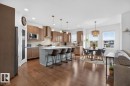Wood-finish flooring throughout, kitchen featuring stainless steel appliances, light wood-finish cabinetry, and a light gray subway tile backsplash - 21 Altadena Point(E), Sherwood Park, AB 