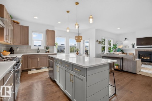 Open-concept kitchen with a large island, wood-finish flooring, and a subway tile backsplash - 21 Altadena Point(E), Sherwood Park, AB 