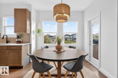 Hardwood-finish flooring, built-in cabinetry, subway tile backsplash, white countertops, and a full-light exterior door - 21 Altadena Point(E), Sherwood Park, AB 