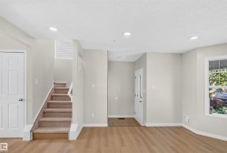 Recessed lighting, wood-finish flooring, carpeted staircase, paneled interior doors, and a front entry door with decorative lites - 