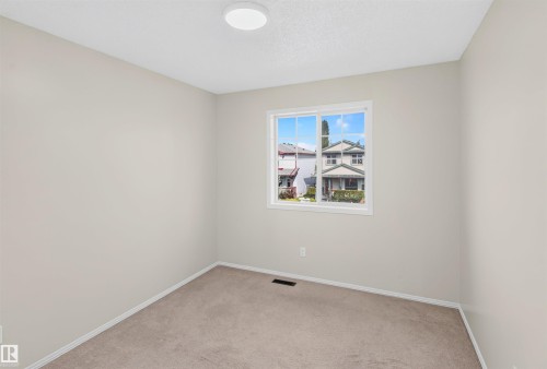 Neutral wall color, carpet flooring, single window, and a ceiling-mounted light fixture - 4409 150 Avenue Nw, Edmonton, AB 