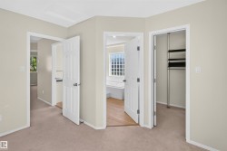 Entryway with carpet flooring, leading to multiple rooms with white paneled doors - 