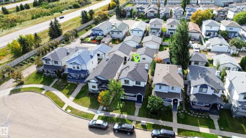 Aerial perspective showcasing residential properties with pitched roofs, varied siding, and established landscaping - 4409 150 Avenue Nw, Edmonton, AB 
