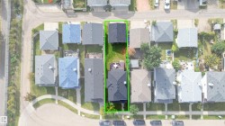 Property with two buildings, including a primary residence and a separate secondary building, each featuring dark shingle roofing - 