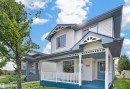 Two-story exterior with light-colored siding, a covered front porch, white railings, and blue trim accents - 4409 150 Avenue Nw, Edmonton, AB 