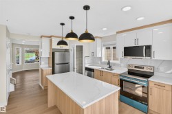 Modern kitchen featuring wood-finish lower cabinetry, white upper cabinetry, and a center island with a light-toned countertop - 