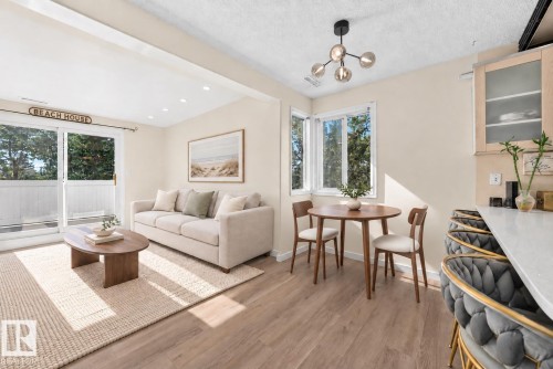 Sliding glass doors with balcony access, wood-finish flooring, recessed lighting, and a modern ceiling light fixture - 161 Lancaster Terrace Nw, Edmonton, AB 