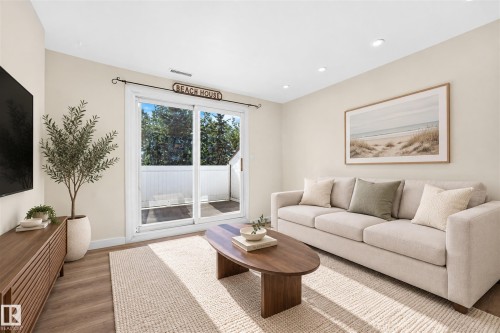 Wood-finish flooring, recessed lighting, and a built-in media console with slatted wood detailing - 161 Lancaster Terrace Nw, Edmonton, AB 