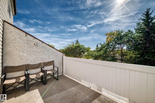 Private outdoor patio with a white privacy fence and stucco exterior - 161 Lancaster Terrace Nw, Edmonton, AB 