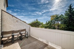 Private outdoor patio with a white privacy fence and stucco exterior - 