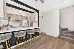 Kitchen featuring wood-finish flooring, white countertops, and light wood cabinetry - 