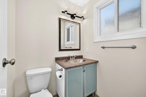 Bathroom with a single-sink vanity featuring a countertop, integrated sink, and cabinet storage - 161 Lancaster Terrace Nw, Edmonton, AB 